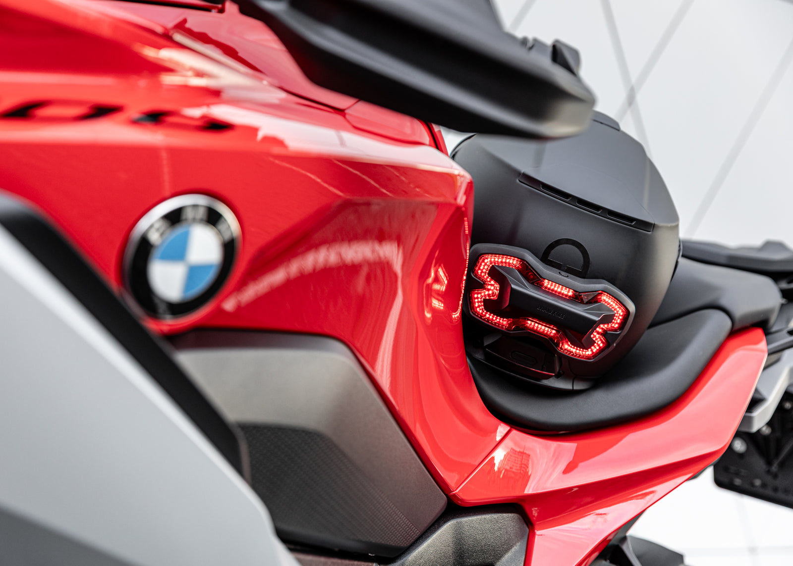 Rear view of Matte Black Schuberth C5 helmet with Covert Black Brake Free unit lit on BMW S1000XR seat